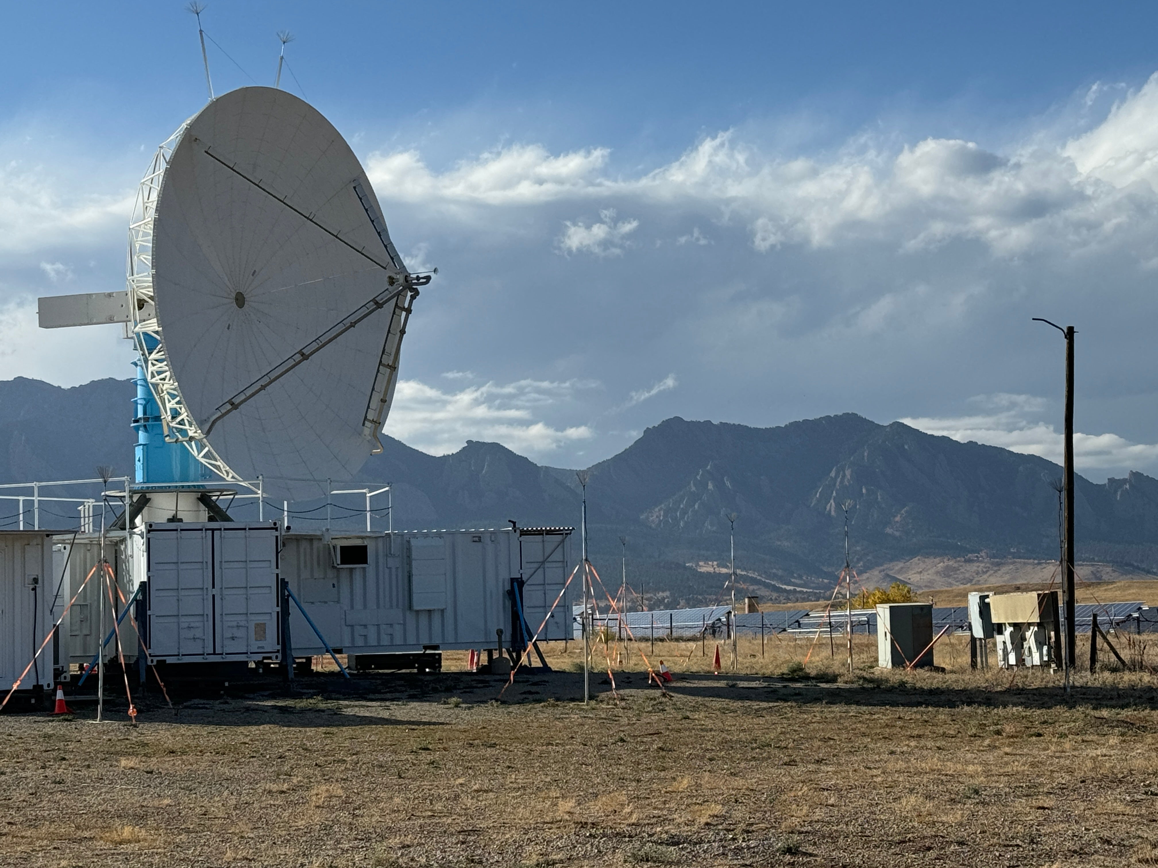 Large doppler radar at Marshall Field site with flatirons mountains in the background. 