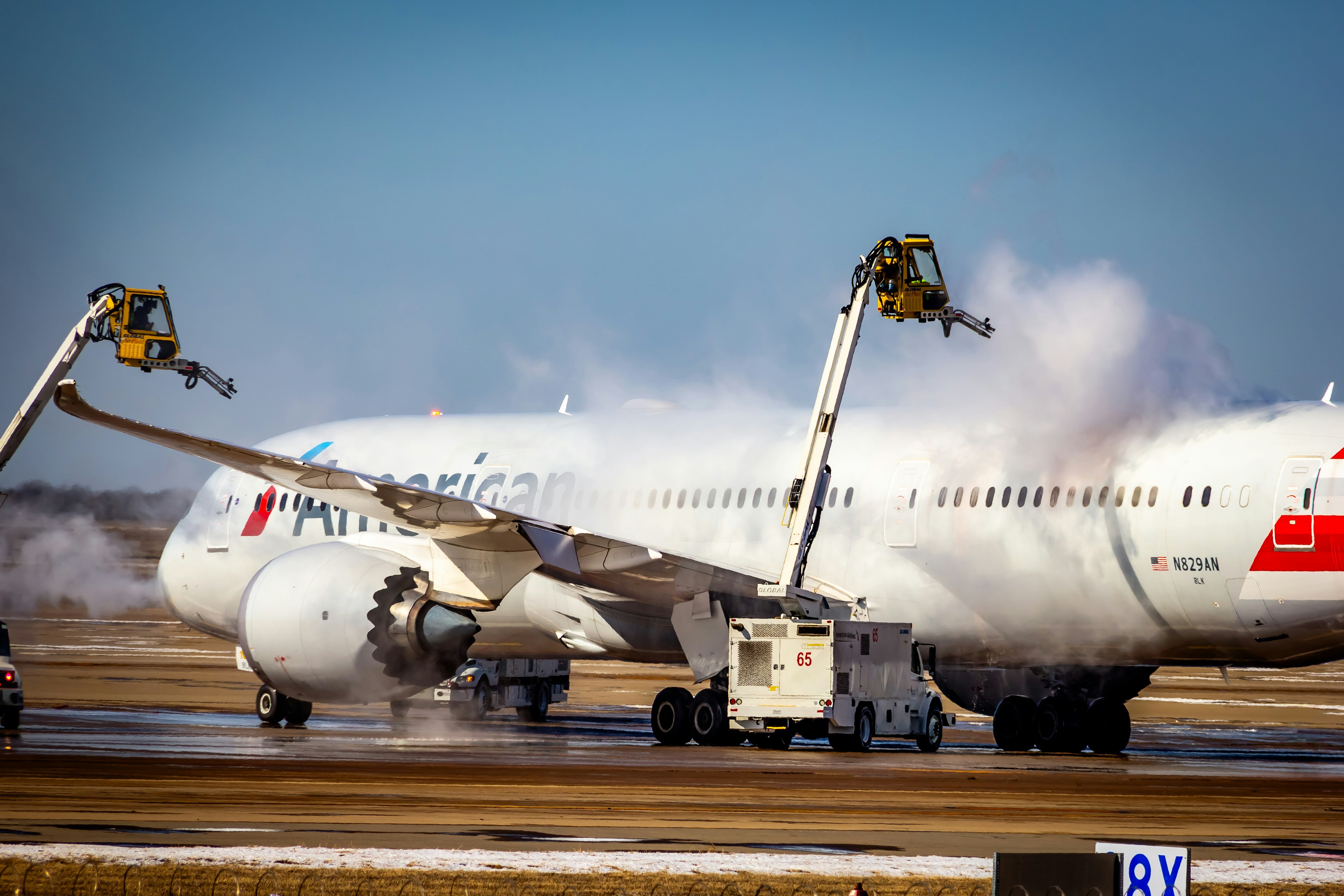 Ground crews apply de-icing agents to an American airlines jet. 