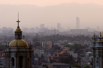 Photograph of pinkish gray air over a cityscape