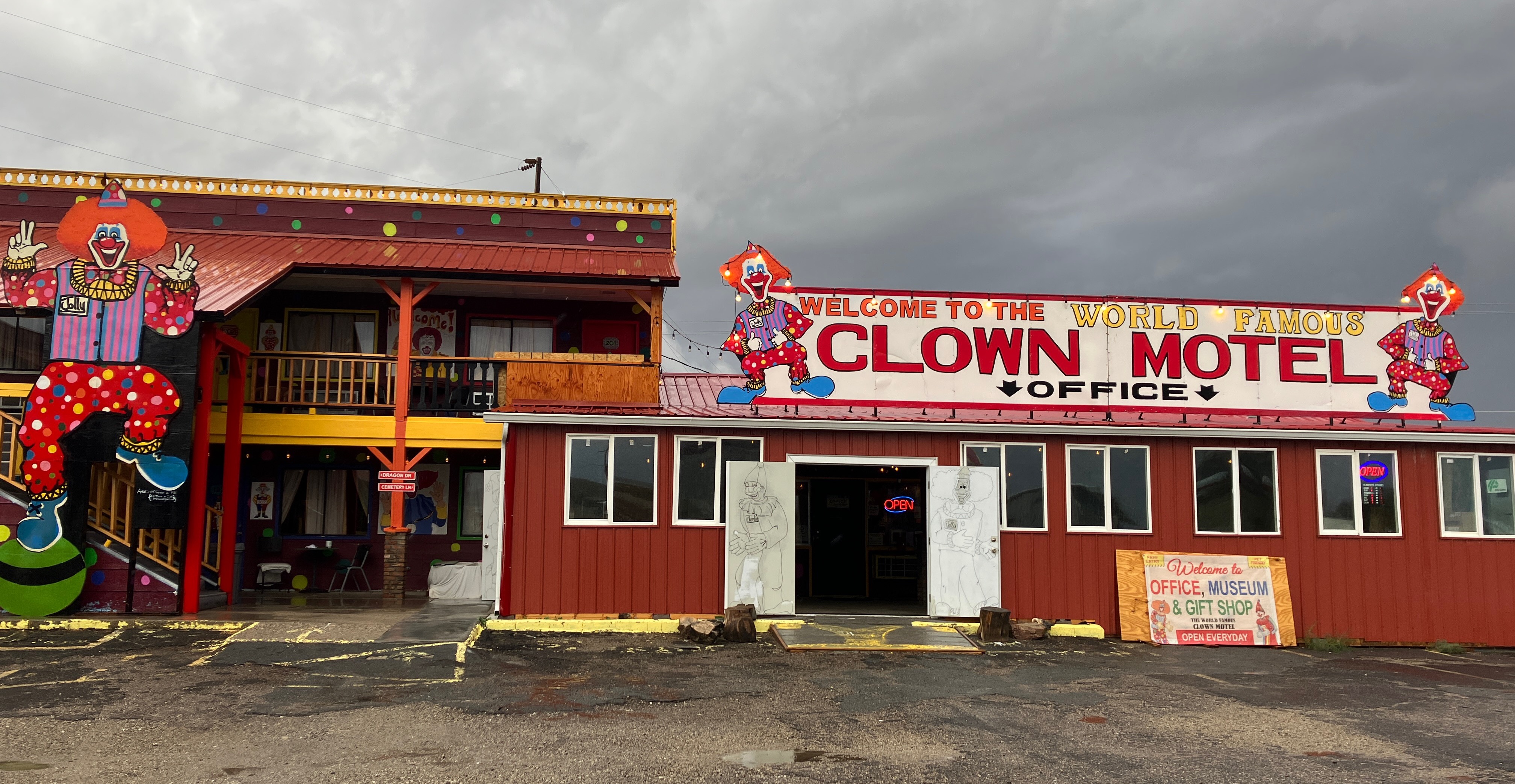 A motel with three large painted clowns decorating the exterior of the building.