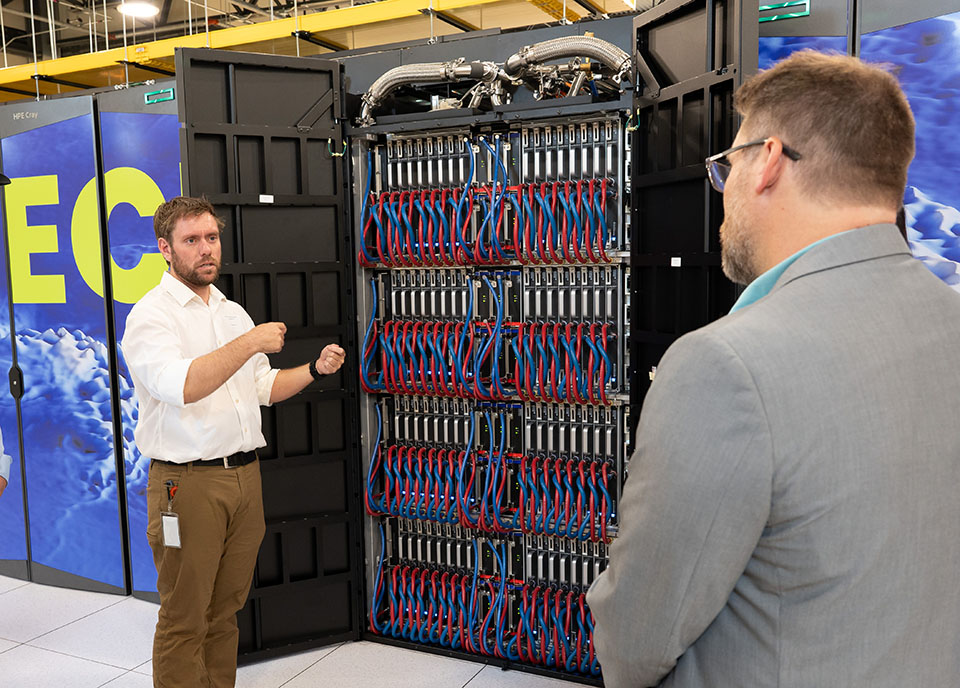 Jared Baker, a systems engineer at NWSC, displays one of Derecho's cabinets. The new supercomputer will enable major breakthroughs in Earth system science. (Image: UCAR)