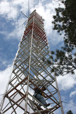 Photograph of a tower against a blue sky with some clouds