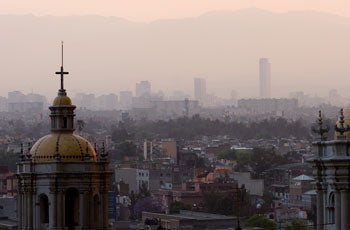 Photograph of polluted, pinkish-gray air over city-scape