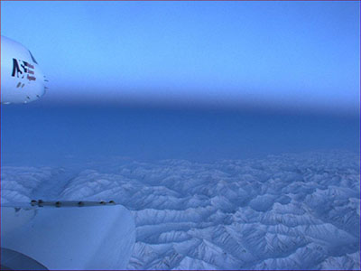 Photograph taken from plane of arctic landscape and blue sky