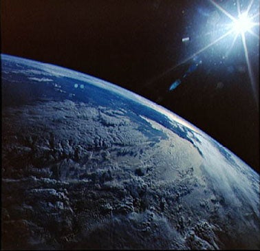 Photograph of the earth and sun from Space Shuttle Discovery
