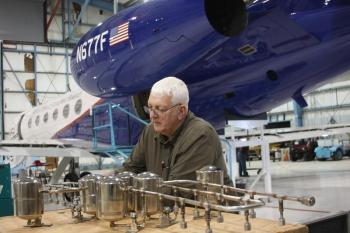 Scientist works on observing instrument with aircraft behind him