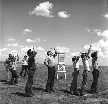 Photo of a group of people looking up at sky