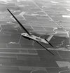Photo of an airplane flying over fields