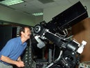 photo of man looking through telescope