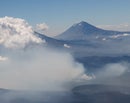Photo of mountains in distance with clouds in foreground