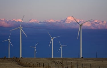 6 turbines in a field, with stratocumulous clouds, at sunset