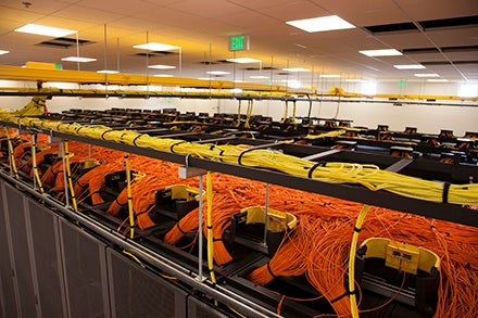 Yellow and orange cables bundled atop the computer racks