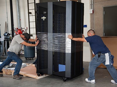 men carefully pushing and pulling a unit into place