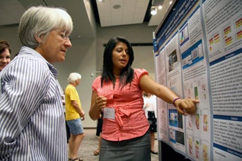 student explains her research during poster session