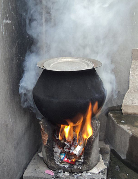 Rural stove using biomass cakes, fuelwood, and trash as cooking fuel