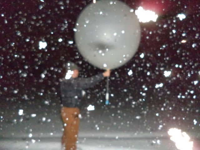 Student launching a weather balloon in heavy snow during OWLes project