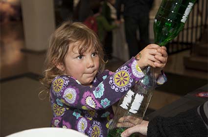 Young girl participating in an experiment at Super Science Saturday.