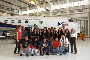 A group of students from Diné College and several NCAR staff standing in front of aircract.