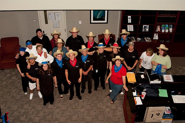 Group photo of the Event Services team wearing straw hats and bandannas.