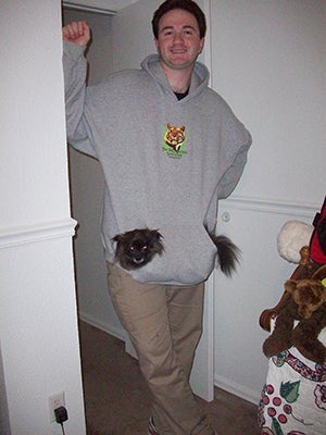 Kelly Craig with a small dog in his sweatshirt.