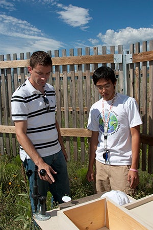 Scott and his intern outdoors looking at instrumentation.