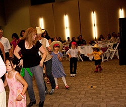 People line dancing at Spring Fling in the CG auditorium.