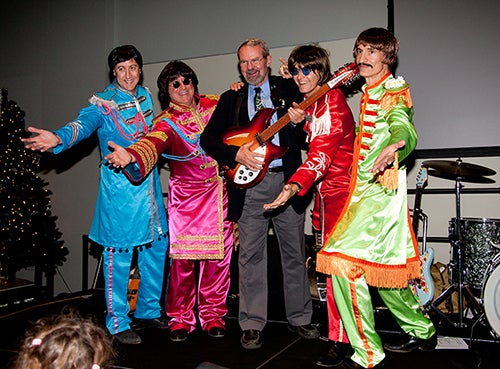 Staff members dressed as ABBA with Rick Anthes in the middle holding a guitar