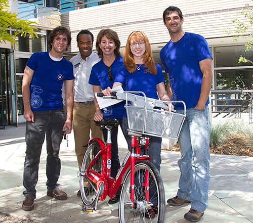 Five people in matching shirts posing outside Center Green.