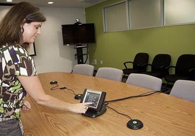 Ligea Ruff dialing the phone in a conference room.