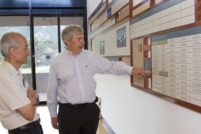 Roger Wakimoto and Guy Brasseur looking at the awards wall.