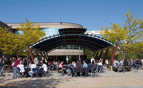 People sitting under the Center Green sunshade.