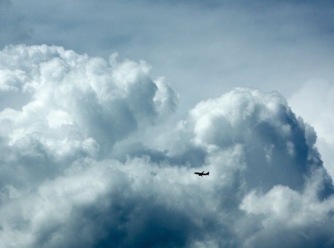 Jet flying through towering cumulus clouds