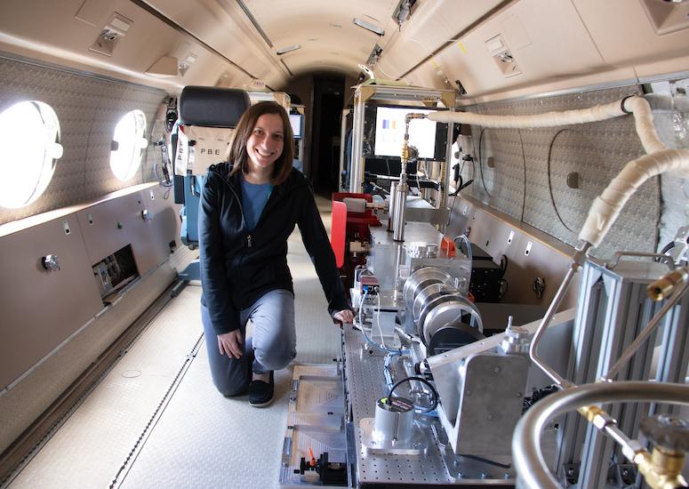 Instrument scientist Jenna Samra kneels next to the Airborne InfraRed Spectrometer (AIR-Spec)