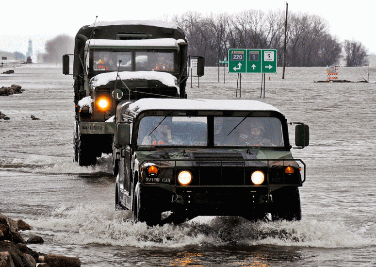 Military vehicles ford floodwaters in Minnesota