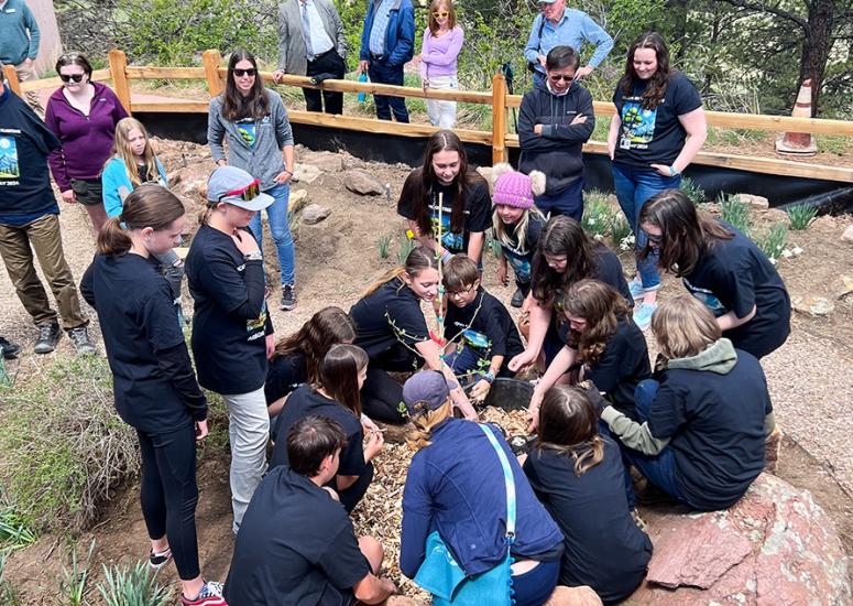 A group of students plant a second generation Moon Tree at the NSF NCAR Mesa Lab.