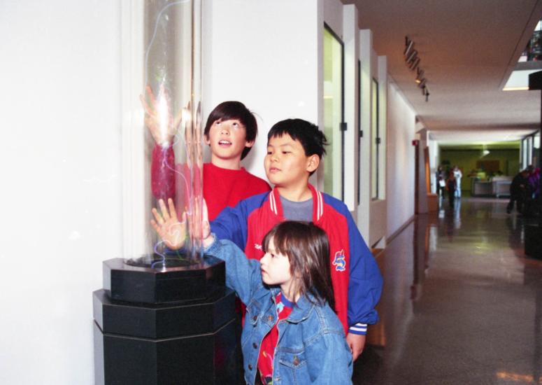 Students touch the lightning machine in the weather exhibit at the NSF NCAR Mesa Lab. 