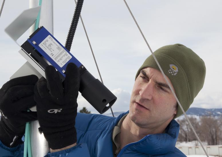 Scientist examines laser instrument for measuring snow