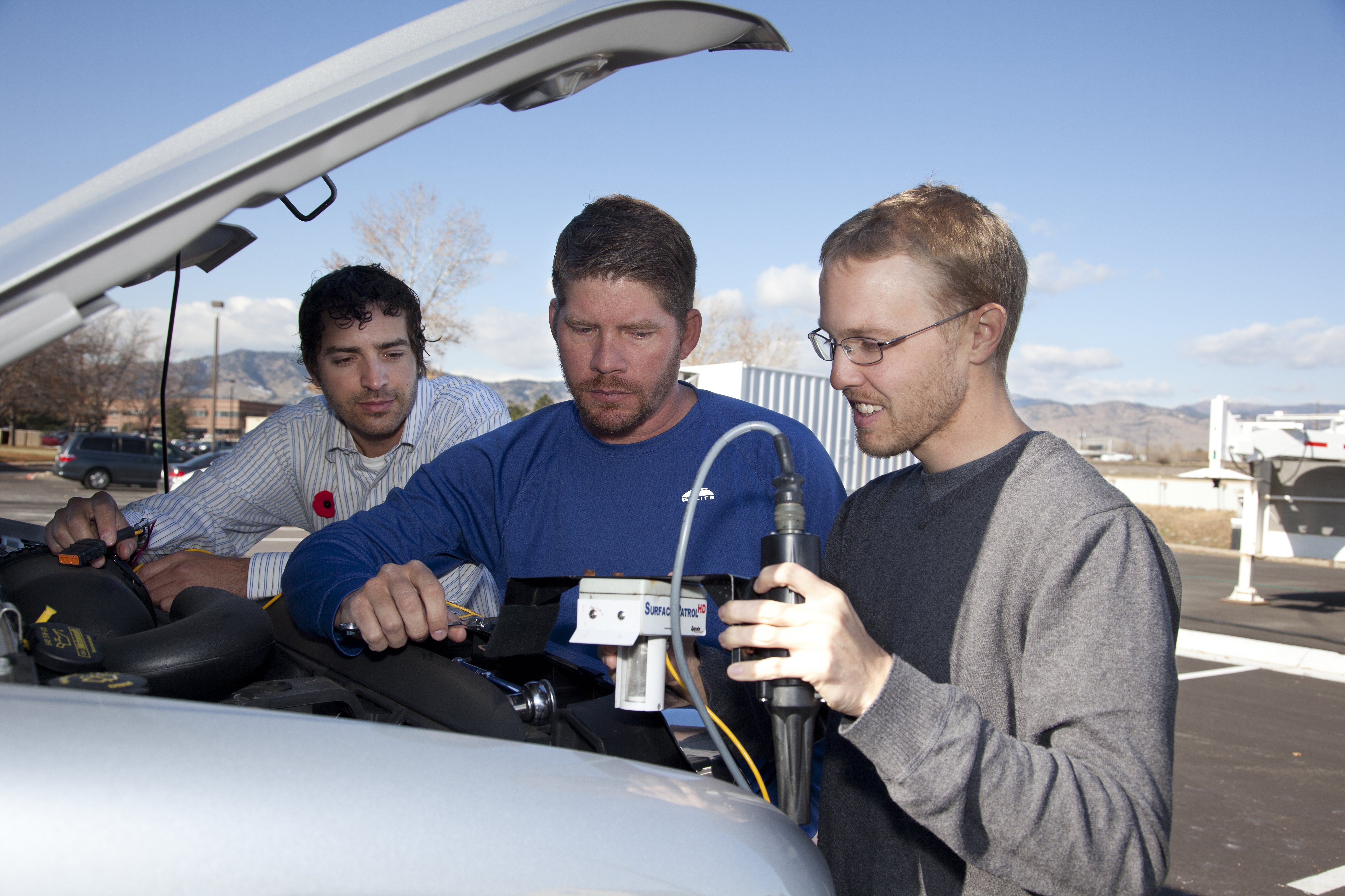 NCAR researchers Sheldon Drobot, Michael Chapman, and Brice Lambi install a vehicular weather sensor.